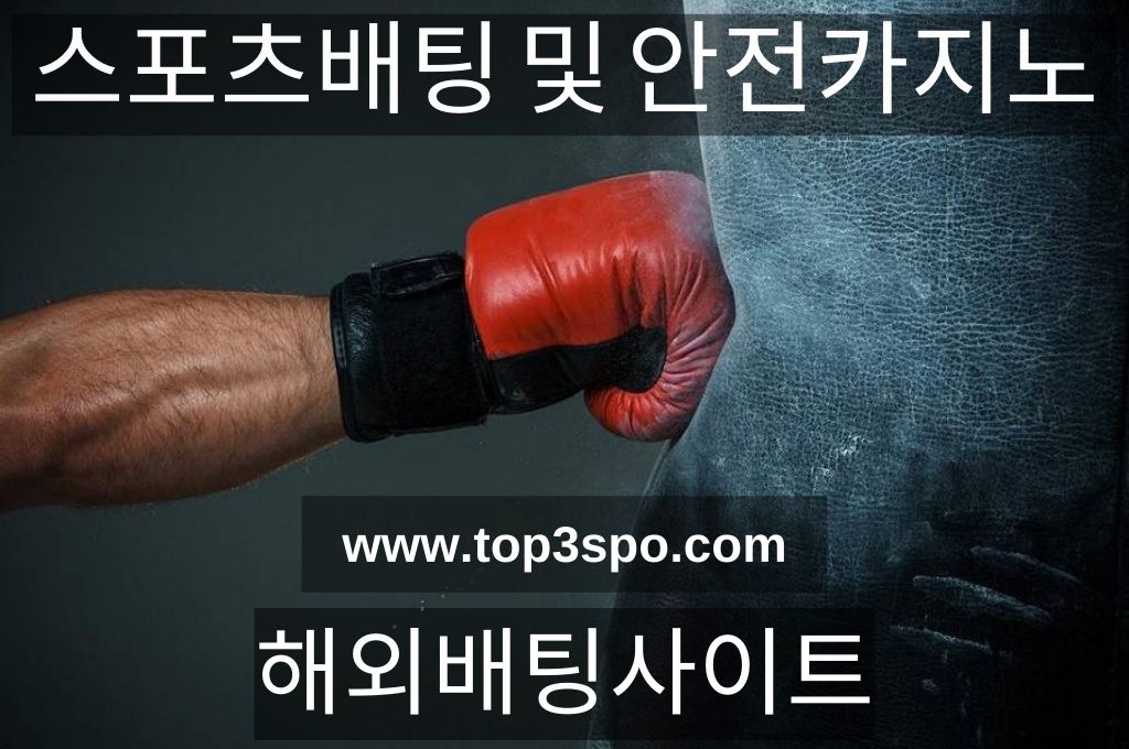 Hand wearing red gloves punches the black punching bag.